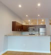 This contemporary apartment offers 910 square feet of thoughtfully designed living space. The open-concept floor plan seamlessly integrates the kitchen, living, and dining areas, creating a spacious feel. The kitchen boasts modern cabinetry, granite countertops, and stainless steel appliances, including a refrigerator and microwave.

Both bedrooms are generously sized, with the primary bedroom measuring 160 square feet. Large windows in the living area and bedrooms flood the space with natural light and provide stunning views of the surrounding cityscape, including a historic building across the street.

The apartment features sleek bamboo flooring throughout the main living areas and bedrooms, while the bathrooms are finished with elegant tile flooring. Built-in shelving in the living area adds both style and functionality. The two full bathrooms are equipped with modern fixtures and ample storage space.

Additional amenities include recessed lighting, a hallway for easy navigation between rooms, and a closet for extra storage. The unit's clean lines, neutral color palette, and high ceilings contribute to its contemporary aesthetic, making it an ideal urban dwelling for those seeking a blend of style and comfort in the heart of the city.
