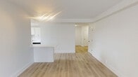 Located at 65 Prospect Street in Stamford, CT, this well-appointed residence offers three bedrooms and two bathrooms across a thoughtfully designed single-floor layout. The open-concept living and dining area is bright and airy, featuring light wood-tone flooring and crisp white walls that create a clean, modern aesthetic. A peninsula counter seamlessly connects the living space to the kitchen, which is outfitted with white shaker cabinetry, quartz countertops, subway tile backsplash, stainless steel appliances including a gas range, microwave, and refrigerator, and a window that brings in natural light and views of the surrounding neighborhood. The spacious primary bedroom offers generous proportions, light wood floors, and ample room for furnishings. The additional bedrooms are similarly finished, each with large windows fitted with blinds that allow for natural light and privacy. Both bathrooms are elegantly appointed; one features marble-look tile flooring, white subway tile surrounding a soaking tub, and brushed gold hardware, lending a refined touch. A dedicated closet provides added storage convenience. The consistent use of light flooring, white finishes, and natural light throughout gives this residence a cohesive, contemporary feel.