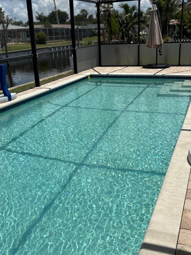 Enjoy the newer pool with paver surround and pool cage, year round. - 4332 S Atlantic Cir