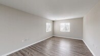 Located at 4038 Battleground Ave in Greensboro, NC, this single-floor residence offers a thoughtfully designed layout with 2 bedrooms and 2 bathrooms. The living room is a standout space, featuring wood-style luxury vinyl flooring, neutral gray-toned walls, and multiple windows dressed with white blinds that invite ample natural light into the room. The kitchen is equipped with stainless steel appliances — including a refrigerator, range, and over-the-range microwave — complemented by crisp white shaker-style cabinetry and granite-look countertops, all set atop matching wood-style flooring. A dedicated pantry provides additional storage convenience. The primary bedroom offers a comfortable footprint with plush carpet flooring, a window for natural light, and closet access. The second bedroom mirrors the clean, neutral aesthetic found throughout the home. Both bathrooms are finished with wood-style flooring consistent with the rest of the unit. A dedicated laundry area and hallway complete the efficient floor plan. Two closets provide ample storage throughout. The overall ambiance is clean, modern, and move-in ready, with a cohesive neutral palette that lends itself to a variety of interior styles.