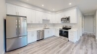 Located at 2210 Rock St in Mountain View, CA, this thoughtfully designed two-bedroom, one-bathroom unit offers a clean, modern aesthetic across a single floor. Light gray luxury vinyl plank flooring runs throughout the space, tying each room together with a cohesive, contemporary feel.

The kitchen is a standout feature, showcasing crisp white shaker cabinets, light quartz countertops, a tile backsplash, and a full suite of stainless steel appliances including a refrigerator, range, microwave, and dishwasher. Recessed lighting illuminates the space efficiently.

Both bedrooms are bright and simply appointed, each featuring neutral gray walls, recessed lighting, a window for natural light, and a wall-mounted ductless mini-split unit for individualized climate control. The primary bedroom offers a comfortable footprint with architectural beam detailing on the ceiling. Two closets provide ample storage throughout the unit.

The bathroom is cleanly finished with a white vanity, wood-look tile flooring, and a tub-shower combination dressed in elegant marble-style surround panels with brushed nickel fixtures.

The entryway is open and welcoming, with a modern front door and in-unit laundry access nearby. The overall ambiance is fresh, clean, and move-in ready, reflecting a newly updated interior ideally situated in the heart of Silicon Valley.