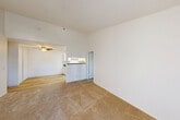 Located at 1725 Marion Ave in Novato, CA, this single-floor, 2-bedroom, 2-bathroom residence offers a well-organized layout designed for comfortable everyday living. The living room features vaulted ceilings, a ceiling fan, and light-toned carpet, creating an open and airy feel. It flows naturally into the combined dining and kitchen area, where light hardwood-style flooring, white cabinetry, dark countertops, and white appliances — including a range, refrigerator, and dishwasher — provide a clean, functional cooking space illuminated by a skylight panel above.

Both bedrooms are carpeted and bright, each featuring closets with sliding doors for ample storage. The primary bedroom offers a comfortable footprint with a dedicated closet and natural window light. The two bathrooms are consistently finished with white cabinetry, dark countertops, and well-lit vanity mirrors; one bathroom includes a shower-tub combination. Additional utility rooms and hallways contribute to the home's practical storage and circulation. The neutral white walls and consistent finishes throughout lend a cohesive, clean aesthetic to the entire residence.