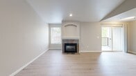 Located at 32200 Military Rd S in Federal Way, WA, this 2-bedroom, 2-bathroom unit offers a thoughtfully organized single-floor layout. The living room serves as the centerpiece of the home, featuring a tile-surround fireplace with an arched built-in alcove above, light wood-look luxury vinyl flooring, recessed lighting, and multiple windows that bring in natural light and views of the surrounding greenery.

The kitchen is efficiently designed in a galley style, equipped with light wood cabinetry, white appliances including an electric range, built-in microwave, refrigerator, and dishwasher, complemented by light wood-look flooring and ample counter space.

Both bedrooms are carpeted and well-proportioned, offering a comfortable retreat. The generously sized primary bedroom includes a sliding double-door closet. The second bedroom features a window for natural light. Each room is finished with neutral warm-toned walls throughout.

The two bathrooms are functionally appointed, each featuring a full tub-shower combination with tiled surround, brushed nickel fixtures and grab bars, a toilet, and wood-look flooring. One bathroom also includes a vanity with storage.

The overall aesthetic of the unit is clean and neutral, with consistent warm beige tones, white trim, and practical finishes throughout.