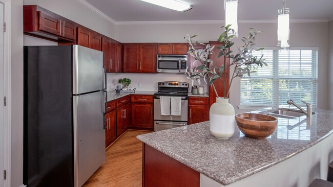 Entertain in style with our two-bedroom kitchens, boasting cherry wood cabinets and luxurious granite countertops for the perfect ambiance. - Rowan Park