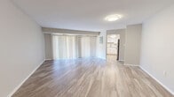 Located at 5 Stonewain Ct in Towson, MD, this well-appointed two-bedroom, two-bathroom single-floor home offers a clean, modern aesthetic throughout. The open living room is a standout space, featuring light wood-style flooring and a wide sliding glass door dressed with vertical blinds that floods the room with natural light and provides outdoor access. The layout flows directly into the kitchen, which has been tastefully updated with white shaker-style cabinetry, granite countertops, a classic subway tile backsplash, and stainless steel appliances including a dishwasher and gas range. A central hallway connects the main living areas to the bedrooms, bathrooms, and laundry, with light wood-style flooring continuing throughout. The primary bedroom is generously sized, offering plush carpeting, a sliding glass door with outdoor views, and a closet. The second bedroom also features wood-style flooring and ample space. Both bathrooms are finished with white cabinetry, granite countertops, and tub-shower combinations. Three closets provide excellent storage throughout. The neutral color palette and consistent finishes lend the home a cohesive, move-in-ready feel.
