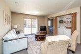 Located at 9614 University Ave in Cedar Falls, Iowa, this single-floor, 4-bedroom, 2-bathroom unit offers a practical and comfortable layout designed to accommodate multiple occupants. The open-concept kitchen and living area forms the heart of the unit, where white cabinetry with warm wood trim accents a well-equipped kitchen featuring a full-size refrigerator, electric range, built-in microwave, dishwasher, and ample counter space with light-colored laminate flooring. The adjoining living room is carpeted and bathed in natural light from large sliding glass doors that open to an outdoor view, creating an inviting and airy atmosphere. Four carpeted bedrooms each feature natural light from sizable windows and generous closet space with warm wood sliding doors, providing each occupant with practical storage. The two bathrooms are finished with neutral tile flooring; one includes a full tub-shower combination, and the other features a vanity with a wide mirror and overhead lighting. A dedicated laundry room and utility room add everyday convenience, while six closets throughout the unit ensure exceptional storage capacity. Textured ceilings and neutral warm-toned walls create a cohesive, understated aesthetic throughout the entire space.