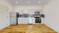 Located at 723 Mount Vernon Ave in Columbus, Ohio, this thoughtfully designed one-bedroom, two-bathroom unit offers a clean, modern aesthetic throughout its single-floor layout. Light-toned hardwood-style flooring flows seamlessly across the open living and kitchen areas, creating a bright, cohesive feel.

The kitchen is a standout feature, showcasing crisp white shaker cabinetry, white quartz countertops, and a slate-blue subway tile backsplash that adds a contemporary touch. A full suite of stainless steel appliances — including a refrigerator, electric range, built-in microwave, and dishwasher — completes the well-appointed space. Recessed lighting illuminates the kitchen and living area overhead.

The bedroom is generously sized, featuring a large multi-pane window that invites natural light and provides views of the surrounding neighborhood. A dedicated closet offers practical storage. Both bathrooms are finished in a clean, minimalist style with tile flooring, wood-toned vanities, white countertops, and matte black hardware accents.

A convenient in-unit stacked washer and dryer is tucked neatly within its own laundry space, alongside a separate utility room. The entire unit reflects a fresh, modern renovation with attention to detail throughout.