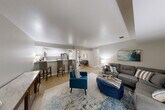 Located at 2021 Georgetown Pkwy in Fenton, Michigan, this single-floor, 2-bedroom, 2-bathroom home offers a well-designed layout with a comfortable and modern aesthetic throughout. The open-concept living and kitchen area serves as the heart of the home, where light wood-style flooring flows seamlessly underfoot. The kitchen is equipped with stainless steel appliances, white shaker-style cabinetry, granite-style countertops, and a breakfast bar with seating — ideal for casual dining or entertaining. It opens directly into a generous living room with neutral walls and ample space for a large sectional sofa arrangement. A separate dining room provides additional space for formal meals. The primary bedroom is a well-proportioned retreat with plush carpeting, while the second bedroom also features carpet flooring and a window allowing natural light. Three closets, including a walk-in with built-in shelving, offer abundant storage throughout the home. Both bathrooms are finished with white cabinetry and granite-style countertops, with light wood-style flooring continuing the cohesive design. A dedicated laundry room and connecting hallway round out the functional floor plan, making this home as practical as it is inviting.