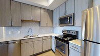 Located at 28 Woolfe St in Charleston's vibrant 29403 zip code, this single-floor residence offers a thoughtfully designed living space with modern finishes throughout. The kitchen is a standout feature, showcasing sleek, light wood-grain cabinetry that extends from floor to ceiling, maximizing storage while maintaining a clean, contemporary aesthetic. A textured tile backsplash adds visual interest and pairs elegantly with the crisp white countertops. Stainless steel appliances, including an electric range and over-the-range microwave, provide a polished, functional cooking environment. The double-basin stainless steel sink is complemented by a modern arc faucet, completing the kitchen's refined look. Light hardwood flooring runs underfoot, lending warmth and continuity to the space. The overall design sensibility balances practicality with modern style, making this Charleston residence a comfortable and attractive place to call home. Its location in the 29403 area places it within easy reach of the city's renowned dining, culture, and historic landmarks.