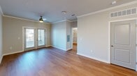 Located at 4415 Percival Rd in Columbia, SC, this well-appointed 2-bedroom, 2-bathroom single-floor home offers a thoughtfully designed layout with modern finishes throughout. Warm hardwood-style flooring flows consistently across the living areas, complemented by neutral gray walls and crisp white trim that create a clean, cohesive aesthetic.

The open-concept kitchen is a standout feature, showcasing white shaker-style cabinetry, white quartz countertops, a subway tile backsplash, and stainless steel appliances including a refrigerator, range, and over-the-range microwave. A central kitchen island with a undermount sink and pendant lighting extends into the living area, enhancing both functionality and flow. The living room features crown molding and French doors that invite natural light.

The spacious primary bedroom includes a walk-in closet with wire shelving and is served by a well-appointed en-suite bathroom featuring a dual-sink vanity, white cabinetry, and a soaking tub with tiled surround. The second bedroom is bright and airy with a ceiling fan and neighborhood views. A dedicated laundry room houses a full-size washer and dryer with overhead shelving for added storage. Two closets provide ample organization throughout the home.