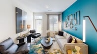 This contemporary 1150 square foot apartment offers a harmonious blend of style and functionality. The open-concept living area is the heart of the home, featuring a vibrant teal accent wall that adds a pop of color to the neutral palette. The well-appointed kitchen boasts white cabinetry, stainless steel appliances, and a convenient island, perfect for meal preparation and casual dining.

The primary bedroom, spanning 220 square feet, is a serene retreat with a four-poster bed, ample natural light, and plush carpeting. Both bathrooms are modern and sleek, with one showcasing a granite countertop vanity and large mirror. The second bedroom continues the apartment's contemporary theme with tasteful decor and access to closet space.

Practical amenities include an in-unit laundry room with storage solutions and a dedicated closet area with built-in organizers. Throughout the apartment, you'll find stylish lighting fixtures, carefully curated artwork, and a mix of hardwood-style flooring and carpeting. Large windows in the living area and bedrooms allow natural light to flood the space, creating a bright and airy atmosphere. The thoughtful layout and design elements make this apartment an ideal urban dwelling for those seeking both comfort and style.