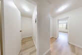 This 2-bedroom, 1-bathroom unit in Surrey, BC offers a clean, functional layout finished with modern updates throughout. Light wood laminate flooring runs continuously across all rooms, complemented by crisp white walls and textured ceilings that lend a bright, airy feel to the space. A central hallway connects the main living areas, providing a logical and efficient flow. The living room is a generous, open space featuring a large window with a balcony door that frames views of surrounding greenery, while a baseboard heating unit ensures year-round comfort. The kitchen is thoughtfully designed in a galley configuration, featuring white cabinetry, marble-style countertops, white subway tile backsplash, and full-size appliances including a refrigerator and stove. The primary bedroom offers comfortable proportions with a built-in closet, while the second bedroom provides additional flexible space. The bathroom is finished with a marble-style vanity countertop, white cabinetry, an integrated sink, and a large mirror with overhead lighting. Additional storage is available via a dedicated closet space accessible from the hallway. The unit's consistent, neutral palette and updated finishes create a cohesive and move-in ready living environment.