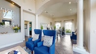 Located at 16200 Space Center Blvd in Houston, TX, this thoughtfully designed single-floor space offers a refined and welcoming atmosphere across its key areas. The entrance greets visitors with soaring ceilings, white decorative columns, and a dramatic chandelier, establishing an immediate sense of grandeur. Large arched windows frame views of the surrounding greenery, flooding the interior with natural light and enhancing the open, airy ambiance throughout.

The main area features rich herringbone-patterned hardwood flooring that flows seamlessly through the space, complemented by neutral warm-toned walls. Bold blue wingback chairs provide striking focal points, adding a sophisticated pop of color against the understated palette. Architectural arched doorways and detailed crown molding reinforce the classical design sensibility.

The dining area is anchored by a round glass-top table surrounded by mixed seating, set against a backdrop of three large arched windows that offer lush outdoor views, making it an especially bright and inviting area.

The private office, accessed via the hallway, offers a more intimate setting with a teal accent wall, ceiling fan, carpeted flooring, and ample workspace — ideal for focused, professional use.

Together, these spaces combine elegant architectural details with functional design to create a polished and comfortable environment.