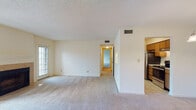 Located at 2140 Pine Tree Ln in Rocky Mount, NC, this single-floor residence offers a well-organized layout designed for comfortable everyday living. The living room is a welcoming focal point, featuring a tile-surround fireplace with a classic mantle and direct access to an outdoor area through a sliding glass door, allowing natural light to fill the space. Soft carpeting extends throughout the living areas and bedrooms, contributing to a warm and inviting atmosphere. Adjacent to the living room, the dining area is defined by an elegant chandelier and connects seamlessly to the kitchen through a pass-through window. The kitchen is equipped with wood cabinetry, light countertops, a stainless steel refrigerator, and tile flooring, offering a functional and efficient workspace. The bedrooms are generously sized, each with plush carpeting and ample closet space, including what appears to be a walk-in closet in the primary bedroom. Two bathrooms serve the home, both featuring tile flooring, a vanity with sink, and a tub-shower combination. Textured ceilings and neutral wall tones are consistent throughout, providing a clean and versatile backdrop. Central HVAC vents are visible in each room, ensuring climate comfort year-round.