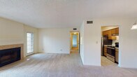 Located at 2140 Pine Tree Ln in Rocky Mount, NC, this single-floor residence offers a well-organized layout designed for comfortable everyday living. The living room is a welcoming focal point, featuring a tile-surround fireplace with a classic mantle and direct access to an outdoor area through a sliding glass door, allowing natural light to fill the space. Soft carpeting extends throughout the living areas and bedrooms, contributing to a warm and inviting atmosphere. Adjacent to the living room, the dining area is defined by an elegant chandelier and connects seamlessly to the kitchen through a pass-through window. The kitchen is equipped with wood cabinetry, light countertops, a stainless steel refrigerator, and tile flooring, offering a functional and efficient workspace. The bedrooms are generously sized, each with plush carpeting and ample closet space, including what appears to be a walk-in closet in the primary bedroom. Two bathrooms serve the home, both featuring tile flooring, a vanity with sink, and a tub-shower combination. Textured ceilings and neutral wall tones are consistent throughout, providing a clean and versatile backdrop. Central HVAC vents are visible in each room, ensuring climate comfort year-round.