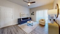 Located at 8120 Mainland Drive in San Antonio, Texas, this two-bedroom residence offers a well-designed single-floor layout that maximizes functionality and comfort. The open-concept living and dining area is anchored by wood-style plank flooring, a ceiling fan, and a sliding glass door dressed with vertical blinds that allows natural light to fill the space. The kitchen features white cabinetry, granite-style countertops, stainless steel appliances including a refrigerator and electric range, recessed lighting, and a peninsula that connects seamlessly to the dining area. Both bedrooms are carpeted and include ceiling fans and windows that bring in natural light. The primary bedroom is a comfortable size and includes access to a dedicated closet with built-in shelving. The bathroom is finished with wood-look tile flooring, white cabinetry with a stone-top vanity, and a full tub-shower combination. A dedicated laundry room accommodates a full-size washer and dryer side by side. The overall aesthetic is clean and contemporary, with a neutral color palette of soft grays and whites that lends a bright, cohesive feel throughout the entire residence.