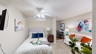 This single-story studio in Metairie, Louisiana, offers a thoughtfully designed layout that maximizes every square foot. A welcoming entry hallway with wood-look flooring and a wall sconce leads into the main living space, where closet doors flank either side for convenient storage access.

The combined living and sleeping area features plush carpeting, neutral-toned walls, and a ceiling fan with integrated lighting. A wall-mounted television, a window with blinds and curtain panels, and a built-in PTAC unit characterize the room. The open layout allows for flexible furniture arrangement, accommodating both a bed and a seating or dining area simultaneously.

The compact kitchen is efficiently organized with light wood cabinetry, white countertops, and wood-look flooring. It includes an electric range, a full-size refrigerator, and a built-in microwave, providing all essential cooking conveniences.

The bathroom features wood-look flooring, a tub-shower combination with a curtain, an over-toilet storage cabinet with an open display niche, and a towel bar. A textured ceiling is consistent throughout the unit, lending a classic character to the overall interior.