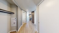 Located in the heart of Seattle at 809 S Washington St, this modern single-floor residence offers one bedroom and three bathrooms with a thoughtfully designed open layout. Light hardwood-style flooring runs throughout the main living areas, complemented by neutral tones and clean architectural lines. A welcoming hallway leads into the heart of the unit, where the kitchen and living room occupy a bright, open space flooded with natural light from expansive floor-to-ceiling windows. The kitchen is outfitted with two-tone cabinetry in warm wood and soft grey tones, a marble-style tile backsplash, stainless steel appliances including a gas range and French door refrigerator, and a central island with a stone countertop ideal for dining or entertaining. Track lighting and pendant fixtures illuminate the space. The generously sized primary bedroom features plush carpet, a built-in closet with shelving and hanging rods, and sweeping floor-to-ceiling glass windows showcasing panoramic Seattle skyline views. Exposed concrete columns add an industrial architectural accent. The bathrooms are finished with granite countertops, wood-toned vanities, and tile-surround soaking tubs. Throughout, the residence balances contemporary urban design with comfort and functionality.