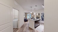 Located at 1100 South Boulevard in Charlotte's vibrant South End neighborhood, this well-appointed one-bedroom, one-bathroom residence offers a thoughtfully designed open-concept layout. Wood-look flooring flows throughout the main living areas, anchoring a seamless combination of dining, kitchen, and living space filled with natural light from large windows.

The modern kitchen is a standout feature, boasting dark espresso cabinetry extending to the ceiling, stainless steel appliances including a refrigerator, electric range, and microwave, and a central island with a granite-style countertop and bar seating for two — ideal for casual dining or entertaining. Pendant lighting and track lighting illuminate the space with style.

The open living area provides comfortable space for relaxing and dining, with access to natural light and an inviting, airy atmosphere. The bedroom offers plush carpeting, a ceiling fan, and a window with exterior views, creating a calm and restful retreat. Three closets throughout the unit offer generous storage.

The bathroom features dark-framed cabinetry, a large vanity mirror, granite-style countertops, and wood-look tile flooring. A dedicated laundry room with a full-size washer hookup and overhead shelving adds everyday convenience. A utility room rounds out the functional offerings of this well-equipped residence.