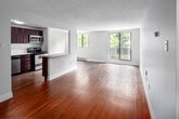 Located at 170 Old Carriage Dr in Kitchener, Ontario, this 2-bedroom, 1-bathroom unit offers a well-organized, single-floor layout with a clean, functional design throughout. Warm hardwood flooring flows consistently across every room, creating a cohesive and inviting atmosphere.

The open-concept living and kitchen area forms the heart of the unit. The kitchen is equipped with stainless steel appliances, including a refrigerator, stove, and over-the-range microwave, complemented by rich dark cabinetry and a granite-topped breakfast bar peninsula. The living area benefits from large sliding glass doors and an additional window, flooding the space with natural light and offering pleasant views of the surrounding greenery.

Both bedrooms are comfortably sized, with the primary bedroom featuring a closet and natural light from a dedicated window. The second bedroom includes built-in shelving beneath its window, offering practical storage. Each bedroom frames lush tree views, enhancing the sense of calm throughout.

The bathroom is finished with a full tiled tub-and-shower combination and clean white fixtures. A central hallway connects all rooms efficiently. The textured ceilings, neutral wall tones, and baseboard heating round out this practical and well-maintained unit.