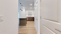 Located at 900 Laura Oaks Blvd in Kissimmee, FL, this well-appointed two-bedroom, two-bathroom residence offers a thoughtfully designed single-floor layout with modern finishes throughout. Light wood-tone flooring flows seamlessly across all living areas, creating a warm and cohesive aesthetic.

The open-concept kitchen and living area serves as the heart of the home, showcasing a striking center island with a granite countertop and a muted teal base, accented by sleek globe pendant lights. The kitchen features a two-tone cabinet design — crisp white upper cabinets paired with warm wood-tone lower cabinets — complemented by a herringbone tile backsplash and a full suite of stainless steel appliances. A barn-style door adds a contemporary architectural detail to the space.

Both bedrooms are bright and cleanly finished with white walls and continued wood-tone flooring. The primary bedroom includes a dedicated closet, while natural light filters in through large windows with garden views in the second bedroom. Each bedroom benefits from convenient access to the hallway and closet spaces.

The bathrooms are finished with granite-topped vanities featuring warm wood cabinetry, glass-enclosed showers with tile surrounds, and modern fixtures, maintaining the home's consistent contemporary style throughout.