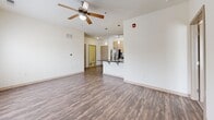Located at 601 NE 70th St in Gladstone, Missouri, this single-floor, 2-bedroom, 3-bathroom residence offers a well-designed layout with a clean, modern aesthetic. The open-concept living and kitchen area forms the heart of the home, featuring durable hardwood-style flooring, a ceiling fan, and natural light from a window and balcony door. The kitchen is equipped with stainless steel appliances — including a refrigerator, range, and microwave — light wood cabinetry, dark countertops, a double-basin sink, and a central island with pendant lighting overhead. Track lighting adds a contemporary touch to the kitchen space. Both bedrooms are carpeted and comfortably sized, with ceiling fans and ample natural light. The generously proportioned primary bedroom includes access to dedicated closet space. Three closets throughout the unit provide excellent storage, complemented by a dedicated laundry area and utility room. The bathrooms feature light tile flooring, wood-toned vanities, and clean, neutral finishes. The entrance leads seamlessly into the main living area, creating an intuitive and functional flow throughout the residence. The overall ambiance is bright, neutral, and move-in ready.