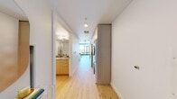 Located on the 27th floor at 757 Thomas St in Seattle's South Lake Union neighborhood, this efficiently designed studio offers a thoughtfully organized single-level layout with two bathrooms and in-unit laundry. The interior features a clean, modern aesthetic with light hardwood flooring and crisp white walls throughout, creating a bright and airy atmosphere.

The kitchen is well-appointed with flat-front cabinetry in a light wood finish, sleek quartz countertops, a subtle tile backsplash, and a full suite of stainless steel appliances including a refrigerator, range, microwave, and dishwasher. The open living area flows naturally from the kitchen, offering flexible space for both sleeping and lounging, with large floor-to-ceiling windows drawing in generous natural light and views of the surrounding cityscape.

Both bathrooms are finished in a contemporary style, with one featuring a vanity with warm wood cabinetry and neutral countertops. A stacked washer and dryer unit is conveniently integrated into the hallway, maximizing efficiency within the compact footprint. The overall design emphasizes smart use of space, modern finishes, and a cohesive, neutral palette that makes the studio feel open and functional.