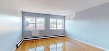 Located at 394 Park Ave in Orange, NJ, this single-floor unit offers a well-organized layout with a clean, functional design throughout. The living areas are highlighted by gleaming hardwood floors that reflect natural light pouring in through multiple windows, creating a bright and welcoming atmosphere. The soft blue-gray walls provide a neutral, versatile backdrop, while baseboard heating ensures year-round comfort. The entry foyer features classic tile flooring that transitions seamlessly into the hardwood living spaces, offering a clear delineation between areas.

The kitchen is equipped with rich, warm-toned wood cabinetry that extends to the ceiling, providing generous storage. A granite-style countertop, stainless steel sink, and a stainless gas range with overhead ventilation complete the functional cooking space, complemented by a classic white tile backsplash.

The bathroom is finished with white subway tile surrounding a full soaking tub and overhead shower, paired with a white vanity and wood-look tile flooring. A small window above the tub allows for natural ventilation and light. The overall layout, as seen in the dollhouse view, flows efficiently between the kitchen, living space, and bathroom, making this a practical and move-in-ready unit in the heart of Orange, NJ.