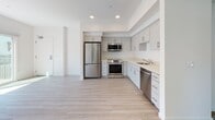 Located at 8585 La Mesa Blvd in the heart of La Mesa, San Diego, this single-floor residence offers a clean, contemporary design with a bright and airy aesthetic throughout. Light-toned luxury vinyl plank flooring runs seamlessly across the living spaces, complementing the crisp white walls and recessed lighting that contribute to an open, welcoming atmosphere.

The kitchen is a standout feature, outfitted with soft gray shaker-style cabinetry, light quartz countertops, and a full suite of stainless steel appliances including a refrigerator, range with over-the-range microwave, and dishwasher. The L-shaped layout provides generous counter space and storage, making it both functional and visually appealing.

The bedrooms are generously proportioned and filled with natural light from large windows that frame views of neighboring rooftops and palm trees — a quintessential Southern California backdrop. One bedroom features mirrored sliding closet doors and a ceiling fan, while another offers direct access to an en-suite bathroom.

The bathrooms are thoughtfully finished with gray vanity cabinetry, quartz countertops, large mirrors, and warm sconce lighting. One bathroom includes a walk-in shower with frosted glass doors, while another features a full soaking tub and shower combination. Both maintain a consistent, polished aesthetic that ties the home together cohesively.