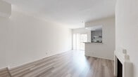 Located at 1210 N Cherokee Ave in the heart of Hollywood, Los Angeles, this thoughtfully laid-out unit offers a bright and functional single-floor living space. The open-concept living room is anchored by a classic white fireplace and bathed in natural light courtesy of sliding glass doors that lead to a private balcony, providing an outdoor retreat with neighborhood views. Light wood-style flooring runs throughout, lending a clean, cohesive aesthetic to the entire unit. The kitchen is well-appointed with gray shaker-style cabinetry, granite-look countertops, a peninsula with a built-in sink, stainless steel appliances including a gas range and refrigerator, and a coffered ceiling detail that adds architectural character. The bathroom features a granite-topped vanity with gray cabinetry, a wall mirror, and a shower-tub combination enclosed by sliding glass doors. A dedicated closet provides practical storage. The unit's crisp white walls and neutral finishes create a versatile canvas, while the efficient layout makes excellent use of every square foot. Its location places residents steps from the dining, entertainment, and cultural attractions that define the Hollywood neighborhood.