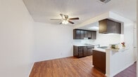 Located in Palmdale, California, this single-floor, 2-bedroom, 2-bathroom residence offers a practical and well-organized layout. Wood-look flooring flows consistently throughout the home, creating a warm and cohesive aesthetic against crisp white walls and textured ceilings.

The open living area is spacious and bright, featuring a ceiling fan with light fixture and a large sliding glass door fitted with vertical blinds that invite abundant natural light and outdoor views. The kitchen is positioned adjacent to the living space and is equipped with rich dark cabinetry, light granite-style countertops, a gas range, an under-cabinet range hood, and a built-in skylight that keeps the area naturally illuminated throughout the day.

Both bedrooms are generously sized, with the primary bedroom offering ample room and direct access to a dedicated walk-in closet. Each bedroom benefits from large windows with vertical blinds that allow for controlled natural light. The two bathrooms are clean and functional — one features a full bathtub/shower combo with white surround, while the second includes a standalone shower stall with granite-style vanity countertops.

A hallway connects the private areas of the home, and two closets provide additional storage. The layout is efficient, making excellent use of the available space throughout.