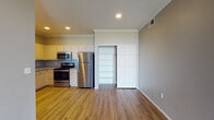 This single-floor residence offers a thoughtfully designed layout that balances comfort and functionality throughout. The kitchen is a standout feature, equipped with stainless steel appliances including a refrigerator, range, microwave, and dishwasher, complemented by light wood cabinetry, granite-style countertops, and durable wood-look flooring. Crown molding and recessed lighting add a polished finish to the space.

The living area is generously sized, featuring rich dark hardwood-style flooring, crown molding, a ceiling fan, and a fireplace that serves as a natural focal point. A sliding glass door fills the room with natural light and provides outdoor access.

The bedrooms are carpeted for comfort, each offering neutral gray walls, ceiling fans, and windows that bring in natural light — one with views of the surrounding landscape. Closet space is well integrated, with sliding doors providing easy access to storage.

Both bathrooms are consistently appointed with wood-look flooring, tiled tub-surround showers, and chrome fixtures. One bathroom features a high window for added natural light. An in-unit laundry area with washer and dryer hookups adds everyday convenience to this well-rounded residence.