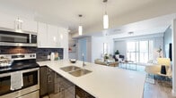 Located at 1792 Pembina Highway in Winnipeg, this well-appointed unit offers four bedrooms and two bathrooms across a single thoughtfully designed floor. The open-concept layout connects the kitchen and living area seamlessly, creating a bright and functional shared space. The kitchen is a standout feature, equipped with white upper cabinetry, dark lower cabinets, a bold navy tile backsplash, quartz countertops, a double undermount sink, and stainless steel appliances including a refrigerator and built-in microwave. Pendant lighting over the island adds a modern touch. The living area flows naturally from the kitchen, with warm wood-look flooring, a neutral accent wall, and large windows that invite natural light and outdoor views. The bedrooms are carpeted and feature generous windows with exterior views, offering a calm and comfortable retreat. The primary bedroom is a cozy yet functional space with ample natural light. Both bathrooms are finished in white with full tub-shower combinations, modern vanities, and dark tile flooring, maintaining a clean and contemporary aesthetic throughout. The overall design balances modern style with practical living, making this a well-rounded multi-bedroom unit.