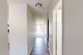 Located in Omaha, Nebraska, this multi-floor home offers a thoughtfully organized layout across three levels. The main floor features a galley-style kitchen and dining area with white cabinetry, dark countertops, wood-look flooring, and black appliances including a refrigerator and dishwasher. A bright, carpeted living room connects seamlessly to the rest of the main level, providing a welcoming and open communal space. Hallways lined with wood-look flooring and textured ceilings connect the rooms, complemented by flush-mount lighting for a clean, functional aesthetic. Both bedrooms are carpeted and equipped with ceiling fans and natural light from double windows. The primary bedroom offers generous proportions along with multiple closets, including a walk-in. The bathrooms are finished with light-toned cabinetry, dark countertops, wood-look flooring, and a full tub-shower surround. An impressive five closets throughout the home ensure ample storage. The unfinished basement presents a versatile open space with painted concrete floors and exposed structural framing, ideal for storage or future customization. A utility room completes the lower level. Staircases connect all three floors, making this home practical and efficient for everyday living.