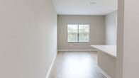 Located at 5790 Stockport St in Riverview, FL, this 3-bedroom, 2-bathroom residence offers a thoughtfully designed single-floor layout with a clean, modern aesthetic throughout. Light-toned luxury vinyl plank flooring runs continuously across all rooms, creating a cohesive and easy-to-maintain living environment.

The kitchen serves as a central hub of the home, featuring white shaker-style cabinetry, a peninsula with a white quartz countertop and an undermount sink with a matte black faucet, and a full suite of stainless steel appliances including a refrigerator, gas range, microwave, and dishwasher. Recessed lighting enhances the bright, functional workspace.

The primary bedroom is a generously sized retreat with a closet and direct access to its own en-suite bathroom, which includes a walk-in shower enclosed by a bold black-framed glass door, a white vanity, and contemporary matte black fixtures. The second bathroom features a single vanity with white cabinetry, a mirror, and modern lighting.

Each of the three bedrooms is finished with neutral warm-gray walls, ceiling fans or light fixtures, and windows fitted with horizontal blinds that allow for natural light and privacy. The overall ambiance is clean, bright, and move-in ready, ideal for comfortable everyday living.