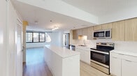 Located at 808 S Wells St in Chicago's South Loop neighborhood, this multi-story residence spans three floors and combines contemporary design with thoughtful architectural details. The open-concept kitchen and living area serves as the heart of the home, featuring light wood-look flooring, a large white quartz island, and stainless steel appliances including a range, microwave, and refrigerator. Cabinetry in a warm wood-grain finish pairs with a white tile backsplash, creating a clean, modern aesthetic.

One of the most distinctive architectural features throughout the space is the curved window design, which wraps around living and bedroom areas to frame expansive views of the Chicago skyline. Large sliding glass doors lead to an outdoor terrace, flooding the interior with natural light. Living areas are bright and open, with light-toned hardwood flooring running consistently across multiple levels.

Bedrooms offer generous proportions and benefit from the same abundant natural light provided by the signature curved windows. Bathrooms are finished with tile flooring, wood-toned vanity cabinetry, white quartz countertops, and a tiled tub-shower combination. Additional rooms feature clean white walls and warm wood flooring, maintaining a cohesive, contemporary feel throughout all three floors.