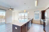 Located at S 34th St & Broadway in Council Bluffs, Iowa, this well-appointed one-bedroom, one-bathroom unit offers a thoughtfully designed open-concept layout across a single floor. Light wood-look flooring flows throughout the main living areas, complementing the clean, modern aesthetic defined by crisp white walls and contemporary finishes.

The combined dining room, kitchen, and living room serves as the heart of the unit. The kitchen features rich dark wood cabinetry, white subway tile backsplash, stainless steel appliances, and an expansive island with a white quartz countertop and an undermount sink — ideal for both meal preparation and casual dining. Pendant lighting above the island adds a refined touch. Large windows and sliding glass doors flood the living area with natural light and provide access to a private patio with open outdoor views.

The bedroom is carpeted for comfort and includes a ceiling fan, a generously sized window with outdoor views, and access to multiple closets offering ample storage. The bathroom is finished with light flooring and features a full tub-shower combination.

Additional highlights include an in-unit laundry area, a well-organized hallway with multiple closets, and a clean, neutral palette throughout that creates a bright and welcoming atmosphere.