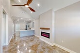 Located at 211 Winter Park Place in Duson, Louisiana, this single-story, 3-bedroom, 2-bathroom home offers a thoughtfully designed open-concept layout. The living room immediately impresses with soaring vaulted ceilings, a striking wood-blade ceiling fan, and a wall-mounted electric fireplace accented by a rustic wood mantle. Polished stained concrete floors flow throughout the entire home, adding a sleek, low-maintenance aesthetic with warm, earthy tones.

The kitchen is well-appointed with gray shaker-style cabinetry extending to the ceiling with crown molding, white quartz countertops, a kitchen island with a sink, and a full suite of stainless steel GE appliances including a refrigerator, range, microwave, and dishwasher. Recessed lighting illuminates the space throughout.

The spacious primary bedroom features a tray ceiling with crown molding, a ceiling fan, a private exterior door with backyard access, and horizontal clerestory windows that bring in natural light while maintaining privacy. All three bedrooms include ceiling fans, and the home offers three closets with built-in shelving and hanging rods for ample storage. The bathrooms feature gray vanities with white quartz countertops and polished concrete floors. A dedicated laundry room with washer and dryer connections completes the home.