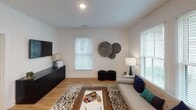 Located at 20 Huguenin Ave in Charleston, SC, this single-floor residence offers a well-designed, open-concept layout with modern finishes and a cohesive contemporary aesthetic throughout.

The kitchen serves as a central hub of the home, featuring granite countertops, gray shaker-style cabinetry, and a full suite of stainless steel appliances, including a range, microwave, and French door refrigerator. A large island with an integrated sink provides generous prep space and seating for multiple guests, making it ideal for both everyday dining and entertaining.

The living area is bright and welcoming, benefiting from multiple windows fitted with white slatted blinds that allow natural light to filter in. Light-toned hardwood-style flooring runs throughout the main living spaces, contributing to a clean, airy feel.

The bedroom is comfortably proportioned, featuring dual windows that offer outdoor views and ample natural light. The space is complemented by a ceiling fan and louvered closet doors for practical storage.

The bathroom features a granite-topped vanity with an undermount sink, a large wall mirror with overhead lighting, and clean white finishes that enhance the sense of brightness.

Overall, the residence presents a modern, light-filled atmosphere with consistent design details throughout.