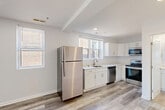 Located at 1101 Euclid St NW in Washington, DC, this efficiently designed 3-bedroom, 1-bathroom unit offers a thoughtfully updated interior with modern finishes throughout. Light-toned, wood-style flooring runs continuously across the entire space, complementing the crisp white walls and creating a clean, cohesive aesthetic.

The open-concept kitchen, dining, and living area serves as the heart of the unit. The kitchen is well-appointed with white shaker-style cabinetry, light quartz countertops, and a full suite of stainless steel appliances, including a refrigerator, electric range, over-the-range microwave, and dishwasher. Multiple windows invite generous natural light, adding brightness to the space.

The three bedrooms are compact yet functional, each featuring light-filled windows — with the primary bedroom benefiting from dual windows offering treetop views. The rooms maintain the same neutral palette and wood-style flooring found throughout.

The bathroom is finished with classic white subway tile surrounding the tub-shower combination, a white vanity with a framed mirror, and matching wood-style flooring, delivering a clean, contemporary feel. A dedicated closet and entrance area round out the layout, maximizing utility within the footprint of this conveniently located DC residence.