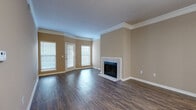 Located at 6100 W 121st St in Overland Park, Kansas, this single-story unit offers a well-organized layout with a blend of practical finishes and comfortable living spaces throughout. The living area serves as the centerpiece of the home, showcasing dark hardwood-style flooring, crown molding, and a tile-surround fireplace that adds a classic focal point to the room. Multiple windows fitted with blinds allow natural light to fill the space, and a glass-paneled door provides direct access to the exterior. Crown molding runs consistently throughout the living area, lending a polished, finished look to the interior.

The galley-style kitchen is efficiently designed with white cabinetry, white countertops, and a full suite of stainless steel appliances, including a refrigerator, electric range, microwave, and dishwasher. Hardwood-style flooring continues into the kitchen, maintaining a cohesive aesthetic.

The bedrooms feature plush carpeting, ceiling fans, and multiple windows that invite natural light. One bedroom includes a walk-in closet and direct access to the bathroom. The bathroom is generously proportioned, offering a long white vanity with ample drawer storage, hardwood-style tile flooring, and a tiled tub-shower combination.
