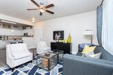Located at 279 E Pebble Hollow Way in Draper, Utah, this single-story home offers a thoughtfully designed layout across two bedrooms and two bathrooms. The open-concept living and dining area is finished with wood-look flooring, a ceiling fan, and ample natural light from large windows dressed with grommet curtains. The living room flows seamlessly into the dining space, which features track lighting and a mirror accent wall, adding depth to the room.

The kitchen is a standout, boasting white shaker-style cabinetry, granite countertops, stainless steel appliances, and a kitchen island — all tied together with the same wood-look flooring found throughout the main areas.

The primary bedroom is generously sized with plush carpet, a ceiling fan, and access to a walk-in closet with built-in shelving and hanging rods. The second bedroom also features carpet flooring and its own closet. Both bathrooms are finished with granite countertops, white cabinetry, wood-look flooring, and a tub-shower combination.

A dedicated laundry room accommodates a full-size washer and dryer and includes open shelving for storage. The home's neutral palette and clean finishes create a bright, welcoming ambiance throughout.