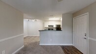 Located at 1994 Bent Creek Way SW in Atlanta, GA, this single-floor, 2-bedroom, 1-bathroom home offers a functional and comfortable layout. The combined kitchen and living area serves as the heart of the home, with the kitchen featuring white cabinetry, dark countertops, wood-style flooring, black appliances including a range and refrigerator, and a breakfast bar peninsula that opens to the carpeted living space. Track lighting adds a modern touch overhead.

Both bedrooms are carpeted and finished in neutral tones, each with a ceiling fan with light fixture and a window fitted with blinds that allow natural light to filter in. The spacious primary bedroom includes multiple doors providing access to a walk-in closet outfitted with wire shelving and additional storage, as well as the hallway. The second bedroom similarly offers natural light and comfortable proportions.

The full bathroom is finished with wood-style flooring and features a tub-shower combo with tile surround. A dedicated laundry room includes a washer/dryer hookup, wire shelving above, and wood-style flooring. A hallway connects all rooms, contributing to an efficient and well-organized floor plan throughout the home.