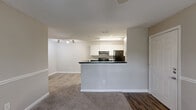 Located at 1994 Bent Creek Way SW in Atlanta, GA, this single-floor, 2-bedroom, 1-bathroom home offers a functional and comfortable layout. The combined kitchen and living area serves as the heart of the home, with the kitchen featuring white cabinetry, dark countertops, wood-style flooring, black appliances including a range and refrigerator, and a breakfast bar peninsula that opens to the carpeted living space. Track lighting adds a modern touch overhead.

Both bedrooms are carpeted and finished in neutral tones, each with a ceiling fan with light fixture and a window fitted with blinds that allow natural light to filter in. The spacious primary bedroom includes multiple doors providing access to a walk-in closet outfitted with wire shelving and additional storage, as well as the hallway. The second bedroom similarly offers natural light and comfortable proportions.

The full bathroom is finished with wood-style flooring and features a tub-shower combo with tile surround. A dedicated laundry room includes a washer/dryer hookup, wire shelving above, and wood-style flooring. A hallway connects all rooms, contributing to an efficient and well-organized floor plan throughout the home.