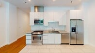 Located at 522 S Boston Ave in the heart of Tulsa, Oklahoma, this modern single-floor unit offers a well-designed layout that balances style and functionality. The kitchen is a standout feature, showcasing crisp white cabinetry, granite countertops, a subway tile backsplash, and a full suite of stainless steel appliances including a gas range, built-in microwave, refrigerator with ice dispenser, and dishwasher. A stainless steel range hood adds an industrial touch overhead, while large-format tile flooring grounds the space cleanly.

The living area transitions seamlessly from the kitchen, featuring warm hardwood flooring that extends throughout the main living spaces. A wall of floor-to-ceiling sliding glass doors floods the room with natural light and opens to a private balcony overlooking lush, mature tree canopies — bringing a refreshing sense of the outdoors inside.

A secondary room also benefits from its own sliding glass door access to the balcony, offering flexibility as a bedroom or additional living space, with the same warm hardwood flooring and clean white walls.

The bathroom is finished to a high standard, featuring large-format white tile flooring, a textured tile walk-in shower with frameless sliding glass doors, a marble-topped vanity, and a large mirror with modern lighting — creating a bright, spa-like atmosphere throughout.