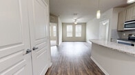 Located at 2650 Dade Ave in Orlando, FL, this 2-bedroom, 2-bathroom residence offers a thoughtfully designed single-floor layout. The open-concept living and kitchen area serves as the heart of the home, where wood-style plank flooring, neutral toned walls, and abundant natural light from dual windows create a bright, welcoming atmosphere. A ceiling fan adds both function and style to the living area.

The kitchen is a standout feature, boasting light wood cabinetry, a granite-topped island with pendant lighting, a subway tile backsplash, stainless steel appliances, and track lighting — all framed by an elegant arched entryway. A hallway with a louvered closet door provides convenient storage near the entry.

The spacious primary bedroom features plush carpeting, a ceiling fan, and multiple windows for natural light. It connects directly to a private bathroom with a wide vanity, light wood cabinetry, and a walk-in closet with wire shelving. The second bedroom also offers carpeted flooring and generous window views. The second bathroom mirrors the home's consistent design aesthetic with matching cabinetry and tile flooring. Both bedrooms include dedicated closets for ample storage throughout.