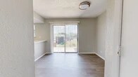 Located at 2316 Fair Oaks Dr in Arlington, TX, this two-bedroom, two-bathroom residence is organized across a single occupied floor, offering a practical and cohesive layout. The living room serves as the central gathering space, featuring plush carpet, a classic fireplace, a textured ceiling, and a sliding glass door fitted with vertical blinds that opens to a private balcony. The balcony provides open views of the surrounding neighborhood, mature trees, and open sky. The kitchen is well-appointed with white shaker-style cabinetry, a white countertop peninsula with an integrated sink, a subway tile backsplash, and stainless steel appliances including a range and over-the-range microwave. Light wood-look flooring runs through the kitchen, dining area, and bathrooms, creating a consistent aesthetic. A pantry and dedicated dining area add to the kitchen's functionality. The spacious primary bedroom features carpet, a ceiling fan, and sliding glass door access to the balcony. The second bedroom is similarly carpeted with a sliding door for natural light. Both bathrooms are finished in a clean, neutral palette with white vanities, tile surrounds, and tub-shower combinations.