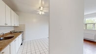 Located at 25 Seeley Dr, Suite 408 in Toronto's northwest end, this one-bedroom, one-bathroom unit offers a practical and well-organized layout across a single floor. The space is thoughtfully arranged to maximize functionality.

The kitchen is outfitted with ample white cabinetry extending to the ceiling for generous storage, a dark laminate countertop, a stainless steel stove, and a full-size refrigerator. White tile flooring runs throughout the kitchen area, complementing the clean, bright aesthetic. An adjacent window fills the living area with natural light and offers pleasant green views of the surrounding trees, while a baseboard heating unit ensures year-round comfort.

The bedroom features warm hardwood flooring, crisp white walls, and a large window overlooking lush greenery — creating a calm and airy retreat. A dedicated baseboard heater is also present in the bedroom.

The bathroom is finished with beige wall tiles surrounding a full soaker tub with an overhead shower, white tile flooring, a curved vanity with under-cabinet storage, and a mirrored medicine cabinet. The overall design is clean and neutral throughout, making this a move-in ready space well-suited for those seeking a manageable, efficient home in Toronto.