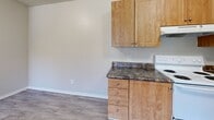Located at 6200 S Campbell Ave in Tucson, AZ, this single-floor, one-bedroom, one-bathroom unit offers an efficient and well-organized layout. The single-level floor plan makes excellent use of its space, with each room thoughtfully defined.

The kitchen is equipped with warm honey-toned wood cabinetry, dark granite-style countertops, and a full suite of white appliances including an electric range, dishwasher, and refrigerator. A double-basin stainless steel sink and ample upper and lower cabinet storage round out the functional cooking space. Wood-look vinyl flooring runs throughout the kitchen and main living areas, adding a clean, cohesive aesthetic.

The bedroom is a comfortable, well-proportioned room featuring plush wall-to-wall carpeting and a window that brings in natural light with an exterior view. A textured ceiling adds subtle character, and a dedicated closet provides personal storage. The room connects easily to the rest of the unit through a standard interior door.

The bathroom is clean and straightforward, featuring a full tub and shower combination with white tile surround, chrome fixtures, and built-in shelving niches. Wood-look flooring continues here, complementing the bright, neutral color palette throughout.

Overall, the unit presents a neutral, move-in-ready interior with consistent finishes and a practical, no-frills design well-suited for single occupancy.