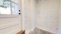 This 970 square foot apartment in Columbia, SC, offers a harmonious blend of modern amenities and industrial charm. The space comprises one bedroom, two bathrooms, and an open-concept layout. The kitchen is a standout feature, boasting dark wood cabinetry, stainless steel appliances, and a subway tile backsplash. The living area seamlessly connects to the kitchen, characterized by exposed white brick walls that add texture and character to the space.

The bathrooms are designed with contemporary aesthetics, featuring granite countertops, dark wood vanities, and large mirrors. One bathroom includes a bathtub-shower combination, while the other offers a sleek walk-in shower. The bedroom continues the industrial theme with its exposed brick wall and concrete flooring, softened by ample natural light.

Throughout the apartment, large format tile flooring in neutral tones unifies the space and complements the white walls. The unit's thoughtful design maximizes its 970 square feet, creating an efficient and stylish living environment. Track lighting and recessed fixtures provide adaptable illumination, enhancing the modern ambiance. This apartment successfully marries functionality with aesthetic appeal, offering a unique living experience in the heart of Columbia.